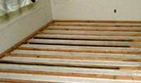 Flexible tubing for hydronic heat in the floor, laid among wooden spacers